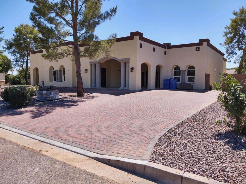 a house with a driveway and trees in front of it