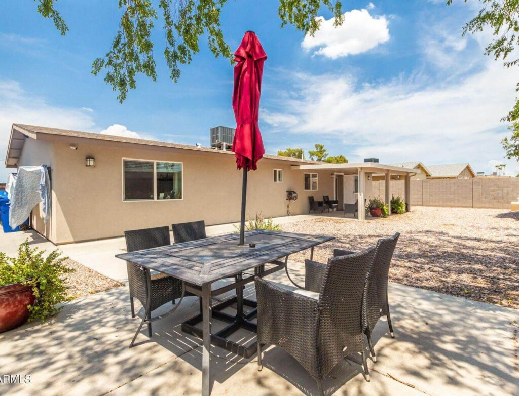 a patio with a table and chairs and an umbrella